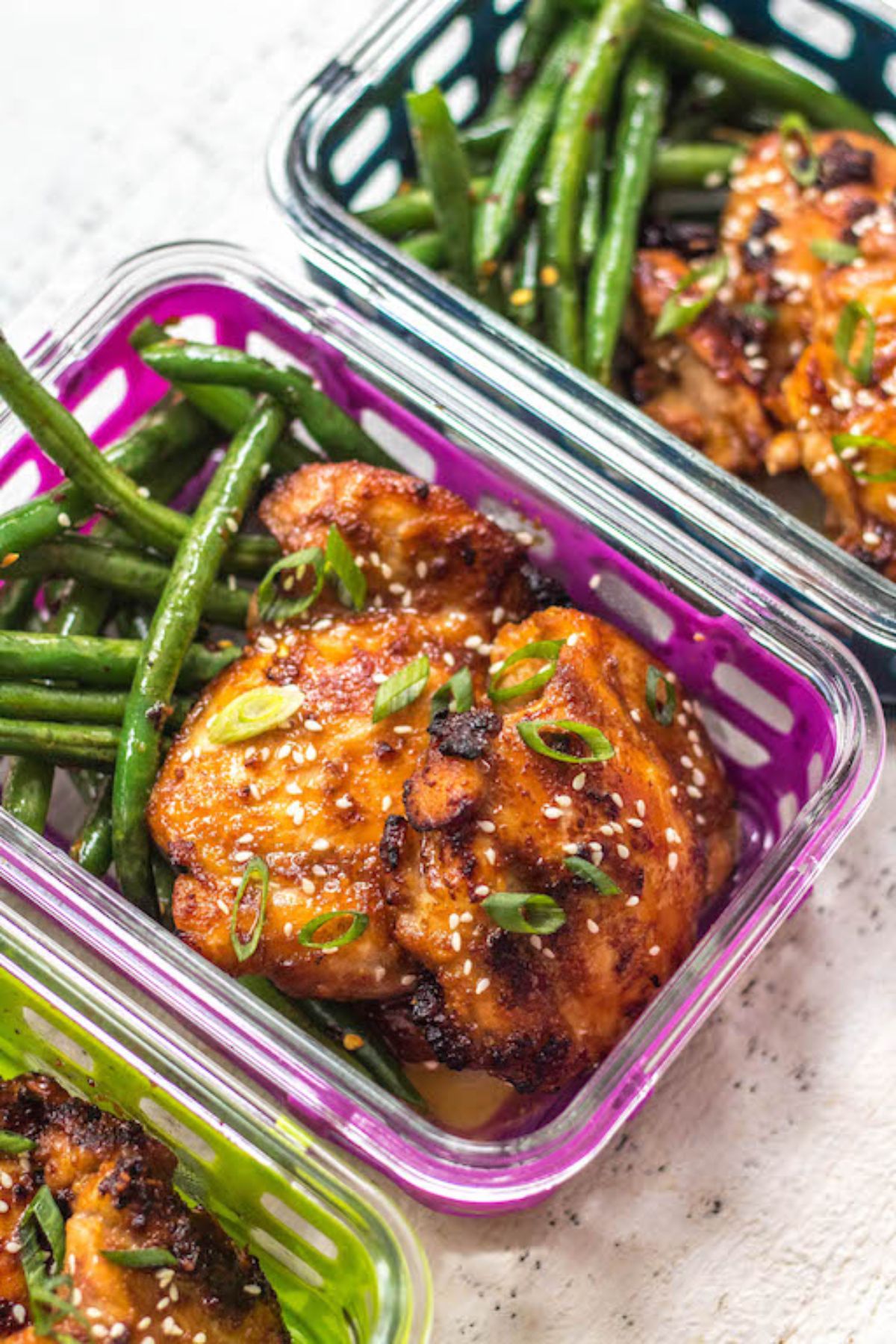 3 containers filled with a chicken thigh, and green beans