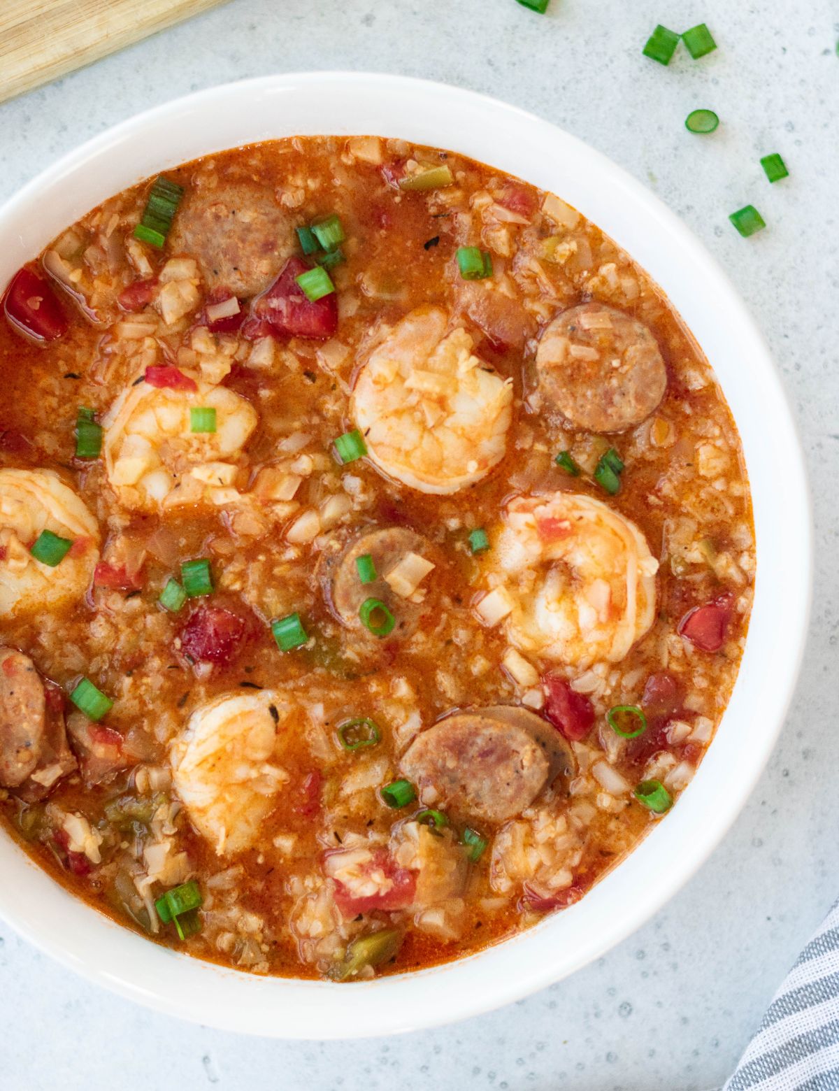 a white bowl of prawn and chorizo soup