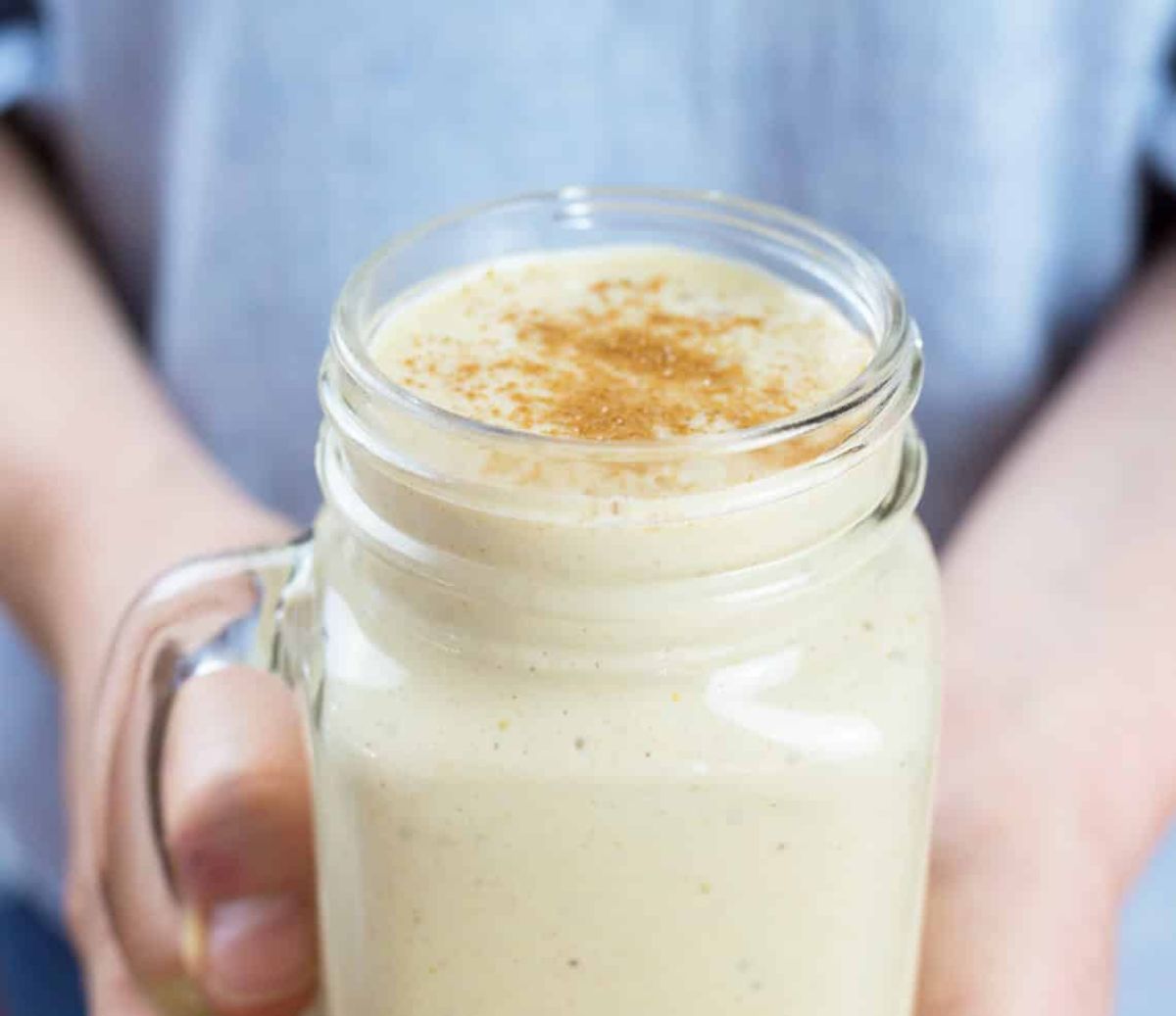 2 hands hold a mason jar full of salted caramel smoothe