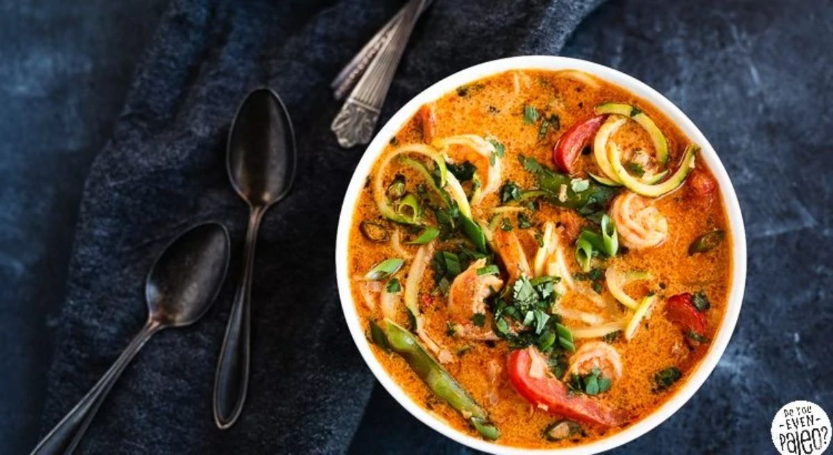 a white bowl of shrimp curry with zoodles and vegetables