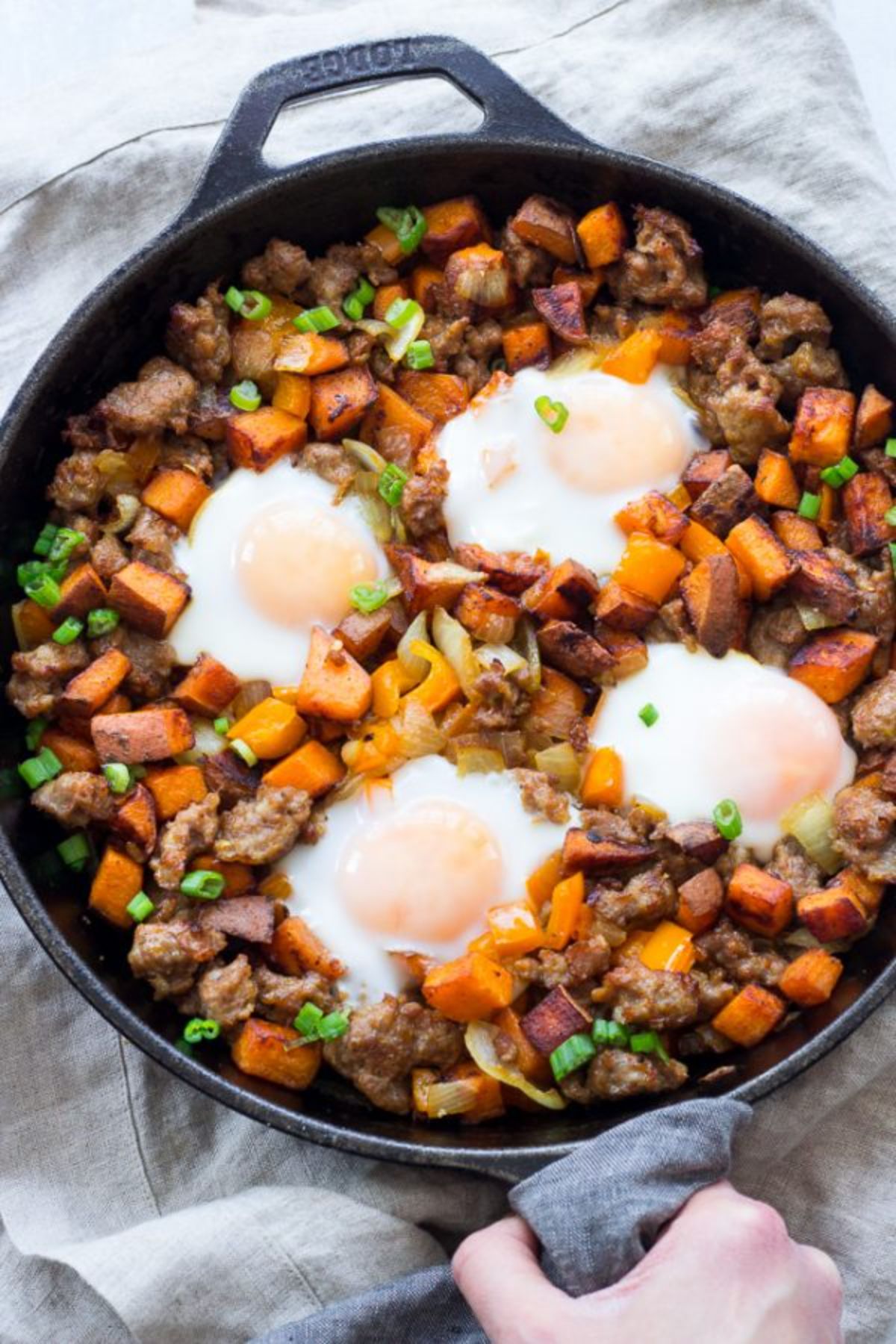 a skillet with sweet potato hash and fried eggs