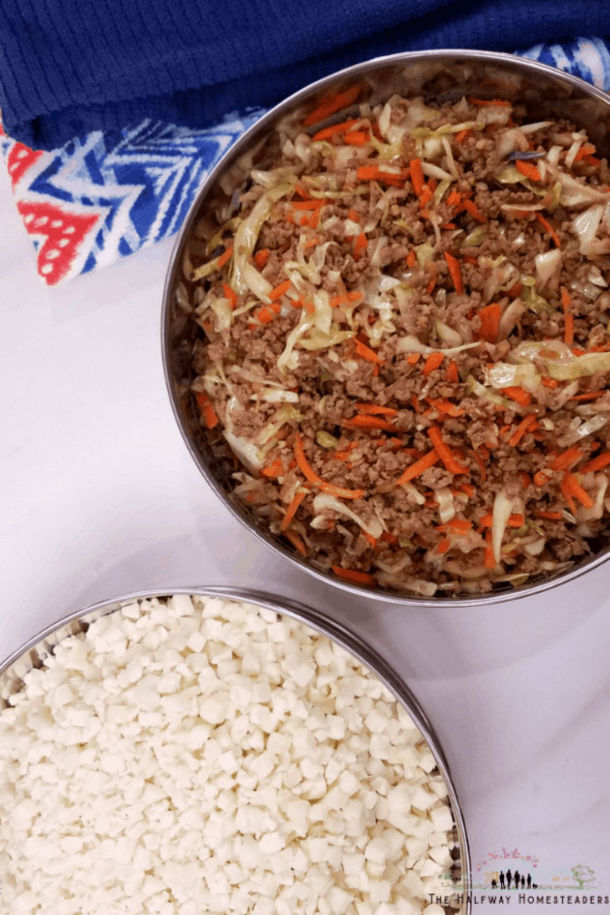 On a white table with a blue cloth at the top of the shot are two silver bowls. One is filled with coconut rice and the other with egg roll mixture