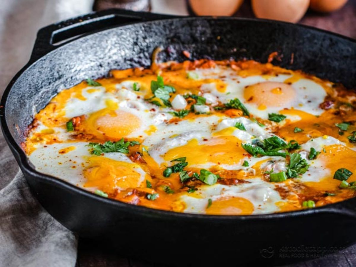 A partial shot of a cast iron dish filled with shakshuka