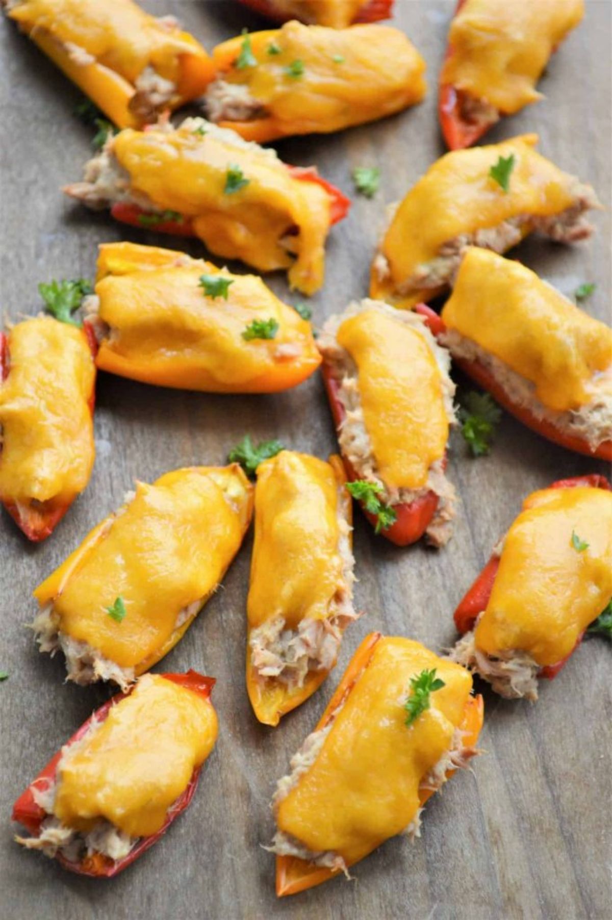 On a wooden table are several cheesy jalapeno poppers.