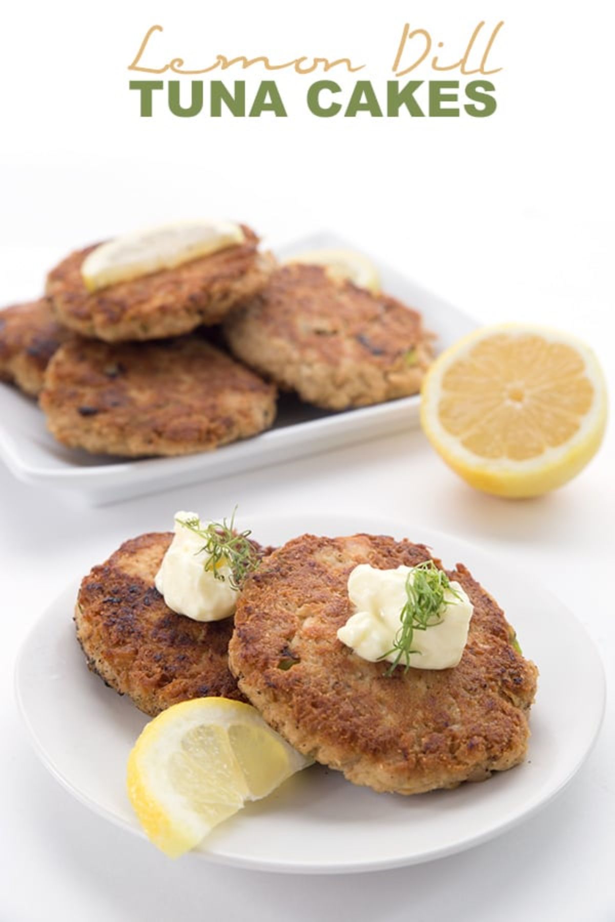 The text reads "Lemon Dill Tuna Cakes". The photo is of one square and one round white plate filled with tuna cakes and topped with sour cream and dill, garnished with lemon