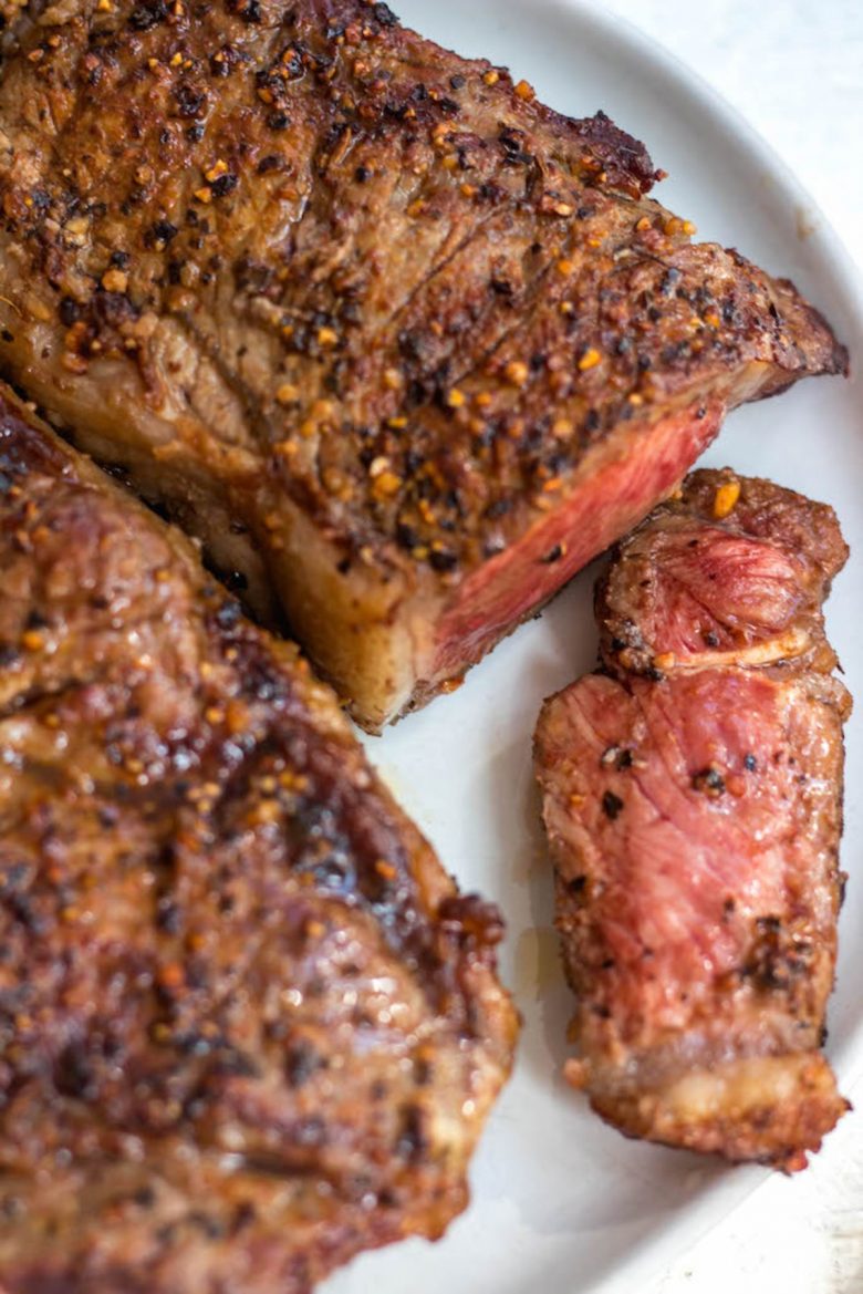 A close iup of 2 steaks, on of which has been sliced into. You can see that it is cooked rare