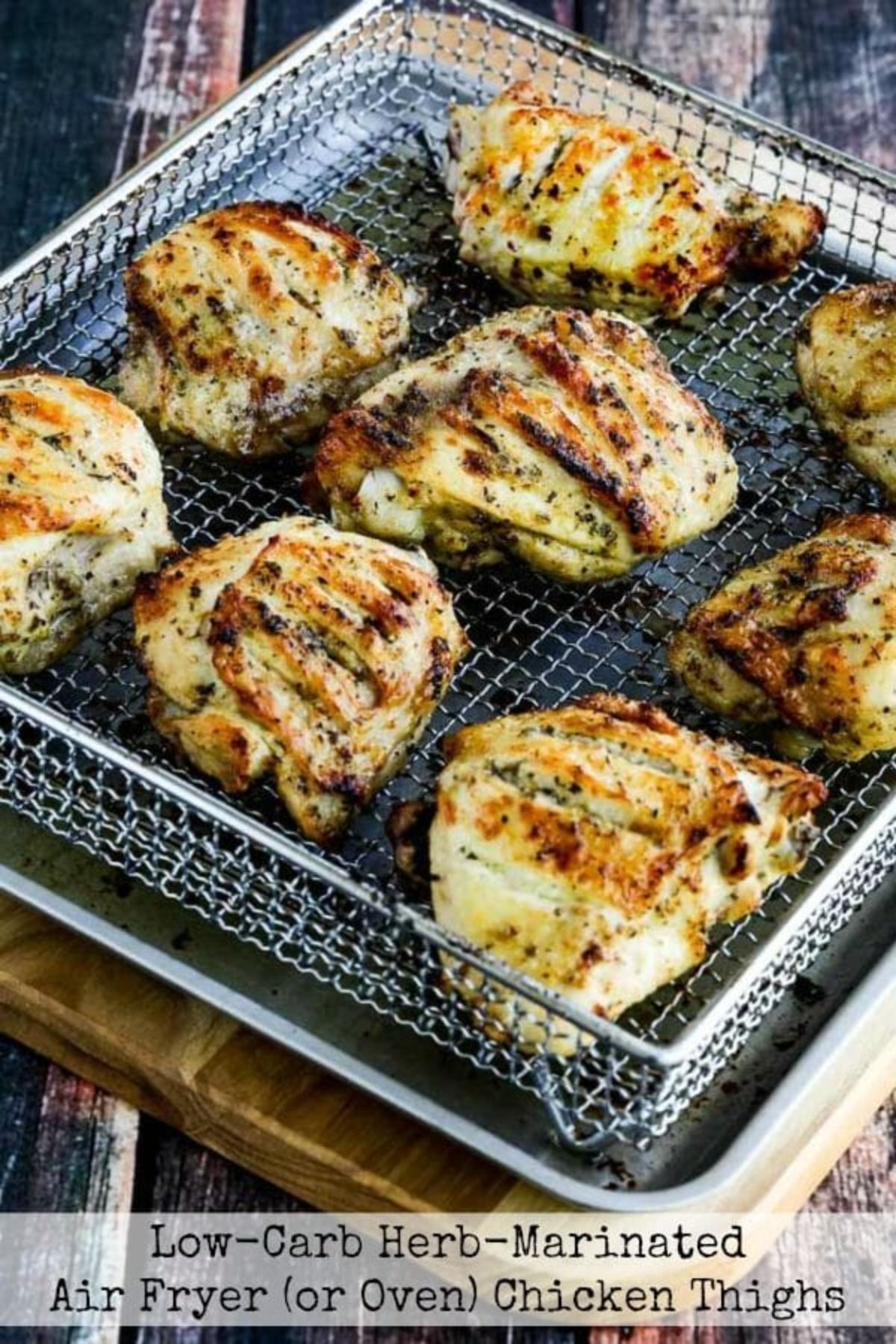 On a wooden board is a wire tray with 8 chicken thighs in it