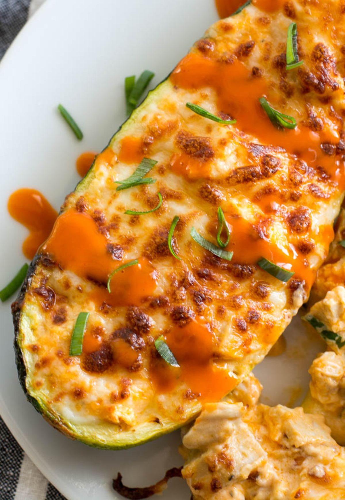 A close up shot of a chicken filled zucchini boat